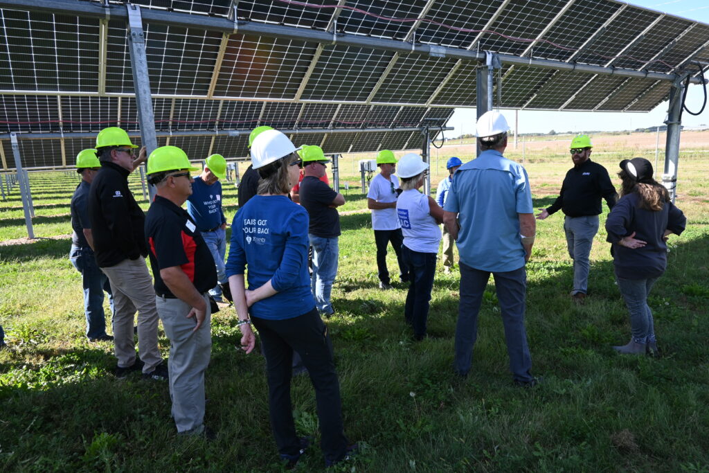 Conference attendees learn about agrivoltaics at a tour of the ISU/Alliant Energy Solar farm in Ames.